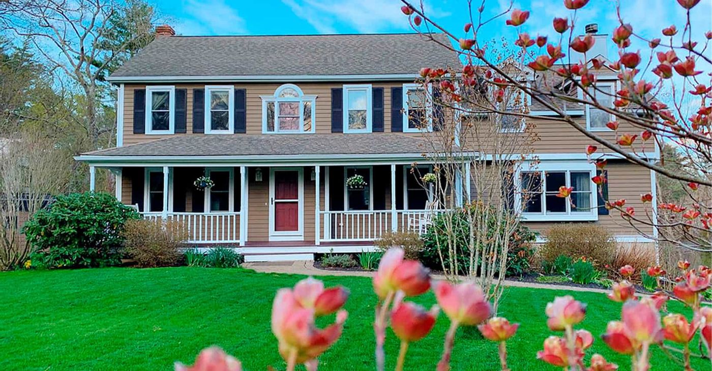 Colonial house with fresh paint behind blooming tulips